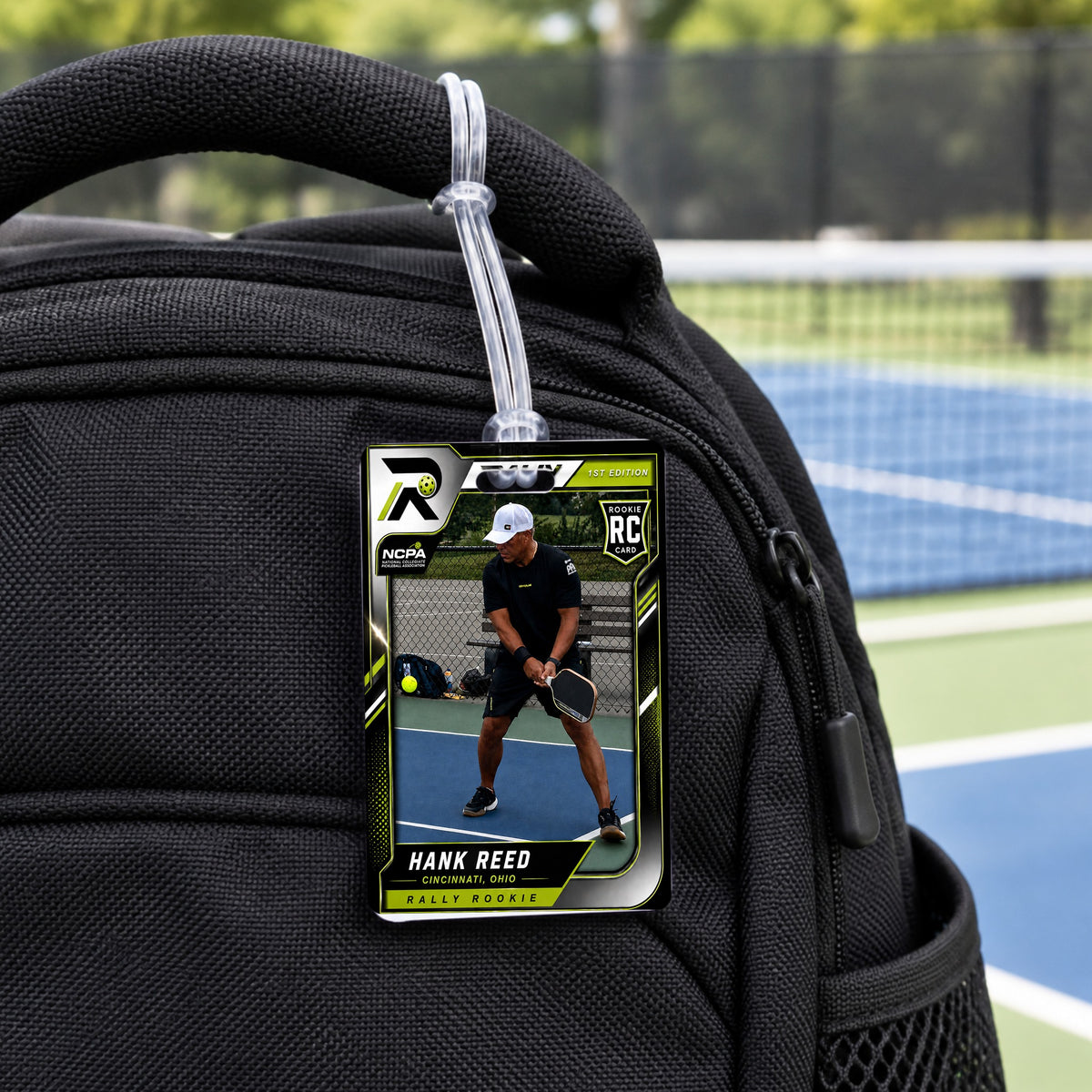 Rally bag tag on a backpack handle: two-sided acrylic tag with the player's Rally card and a clear loop