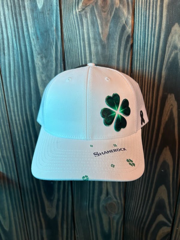The Shanerock hat: a white Richardson 112 with a glossy green four-heart clover, SHANEROCK on the bill and a gold ribbon side patch