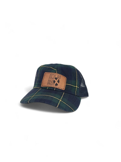 Green tartan trucker hat with a tan engraved leather patch