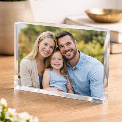 Clear glass photo frame with a family portrait on a wooden surface.